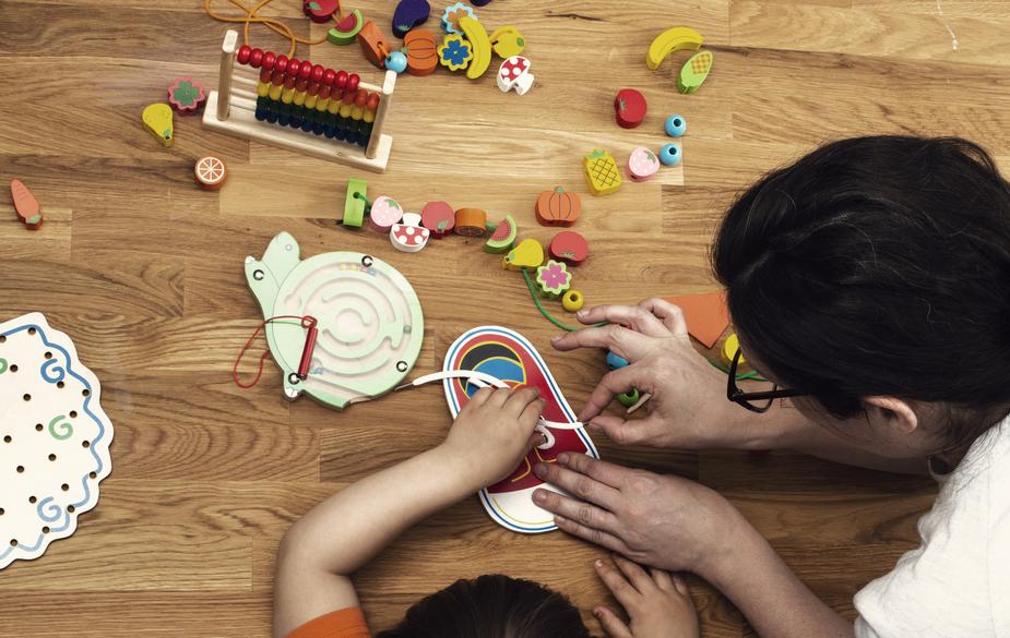 daycare teacher helping a toddler